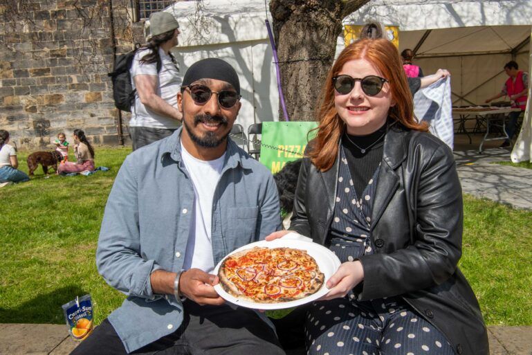 Couple enjoying pizza at Paisley Food and Drink Festival 2024.