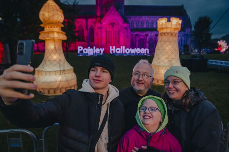 A group pose for a photograph in front of Paisley Abbey at Paisley Halloween Festival 2023.