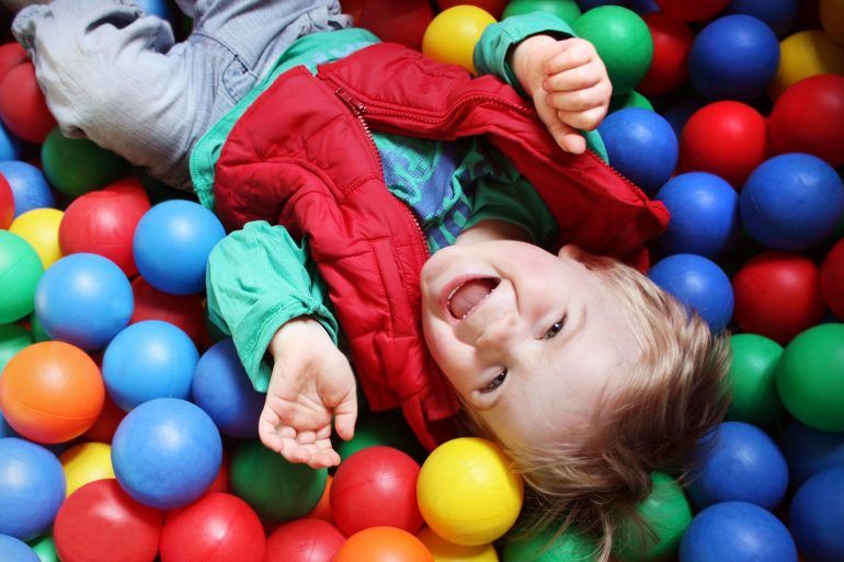 Two year old boy in a pool of coloured balls