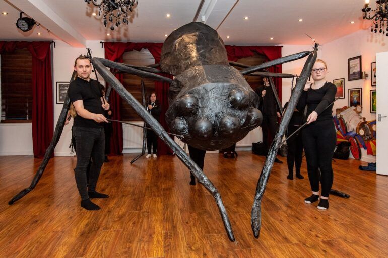 Starlight Musical Theatre pose with giant spider puppet which will appear at Paisley Halloween Festival 2022