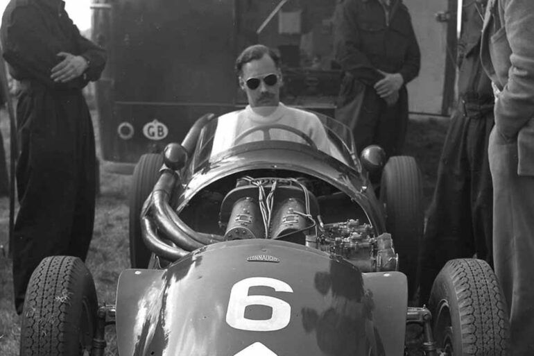Black and white picture of Archie Scott Brown sitting in racing car.