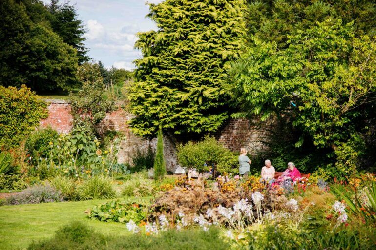 People sitting in Barshaw Park Walled Peace Garden
