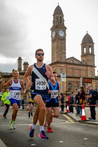 Runners pass Paisley Town Hall during Paisley 10k Road Race 2022.
