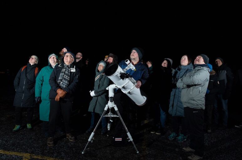 A group of people stargazing with a telescope at Muirshiel Visitor Centre, Lochwinnoch.