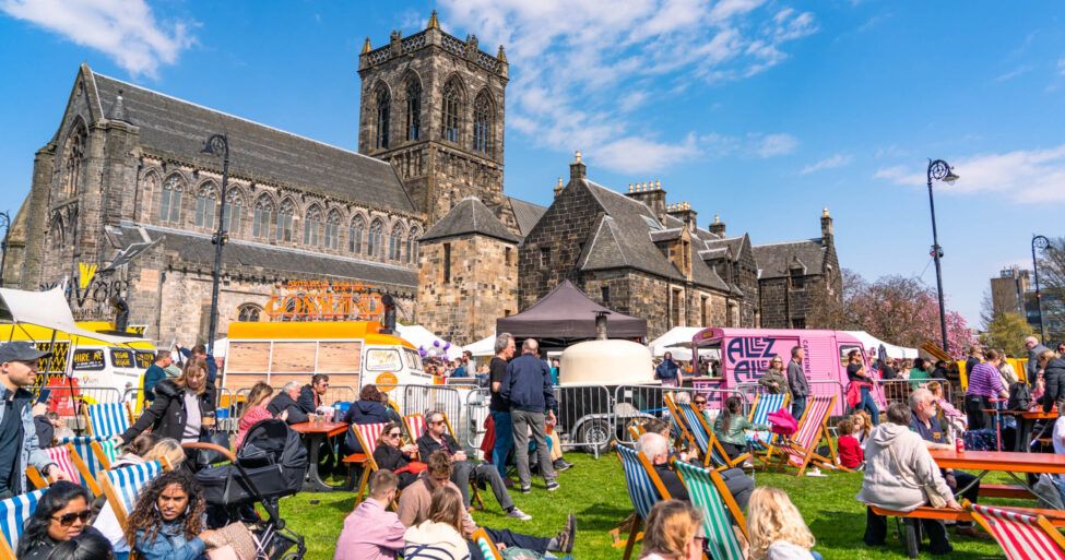 Crowds sitting in the sunshine at Paisley Food and Drink Festival 2023.