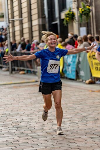 Woman running in Paisley 10k Road Race 2023