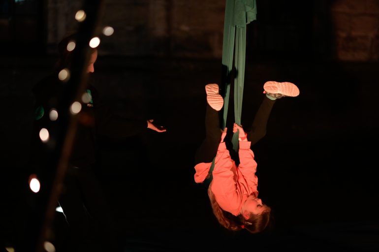 Girl hanging upside down during aerial workshop.